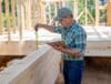Specialist measuring a project site to calculate an accurate building quote.